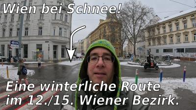 Foto von mir mit einem Kreisverkehr im Hintergrund, Schnee ist an verschiedenen Stellen der Straße sichtbar. Text: "Wien bei Schnee!", "Eine winterliche Route im 12./15. Bezirk."